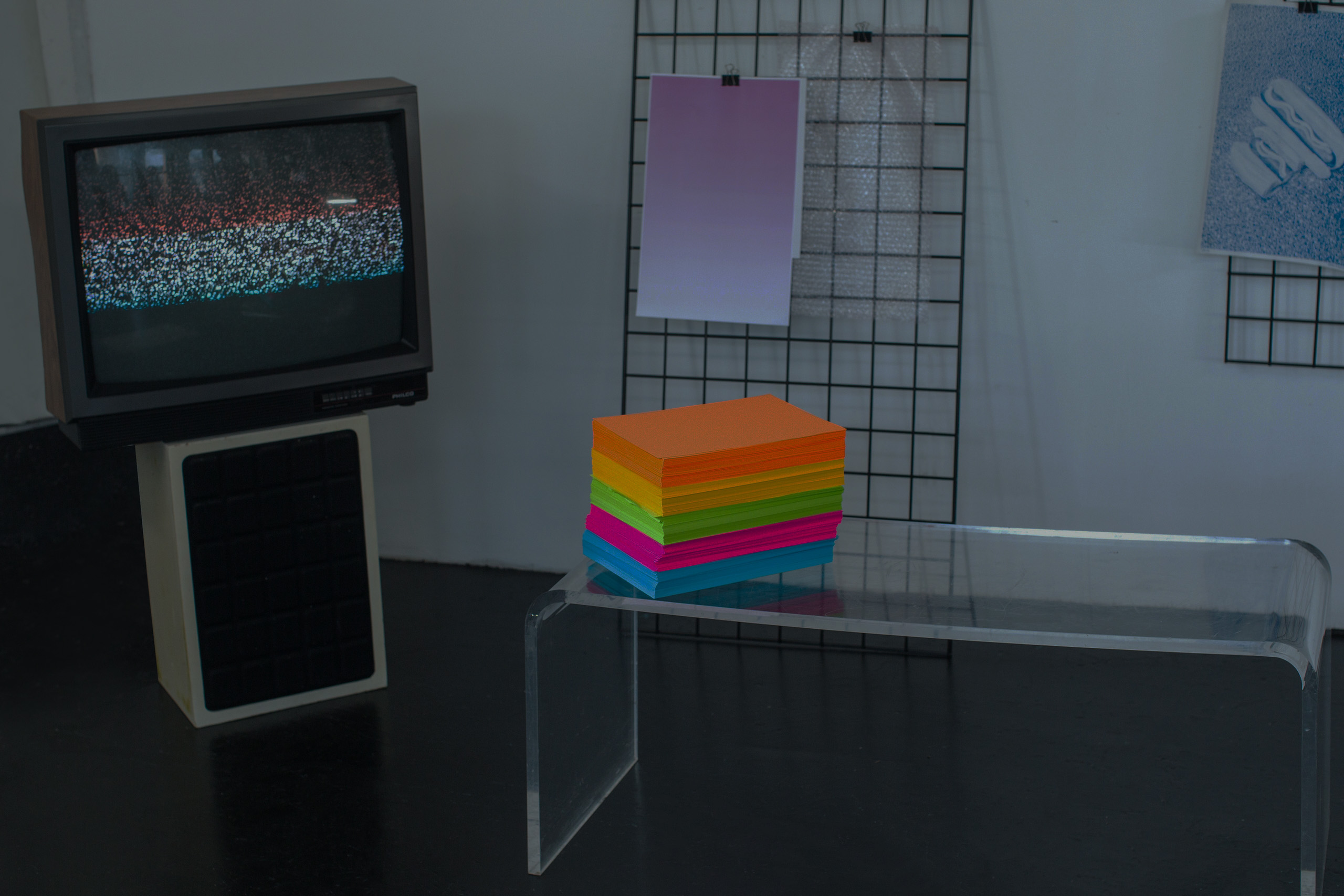 studio with a stack of postits and a tv with static playing