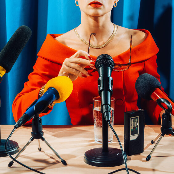 Stylish Female  in front of microphone and cameras at press conference